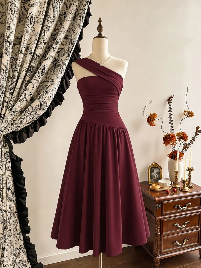 Mannequin front view of the burgundy one-shoulder pleated a-line midi dress, showing the silhouette and fit.