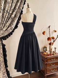 Mannequin front view of the black one-shoulder pleated a-line midi dress, showing the silhouette and fit.