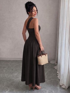 Model back view of the black one-shoulder pleated a-line midi dress, showing the silhouette and fit.