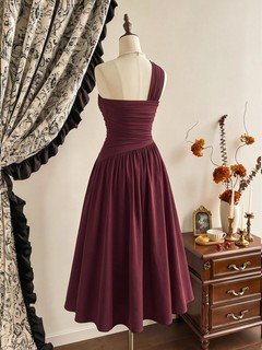 Model back view of the burgundy one-shoulder pleated a-line midi dress, showing the silhouette and fit.