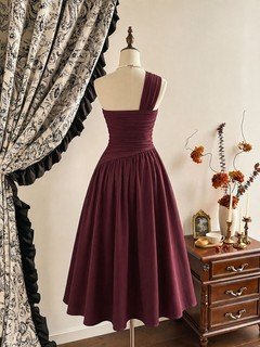 Model front view of the burgundy one-shoulder pleated a-line midi dress, showing the silhouette and fit.