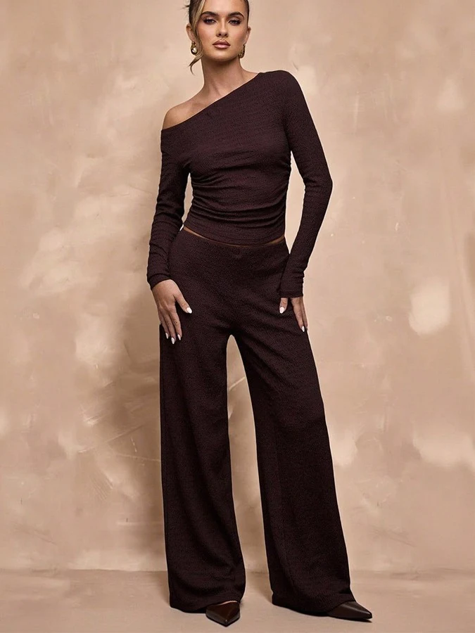 Front view of the brown one-shoulder top and pants set, showing its silhouette and design details.