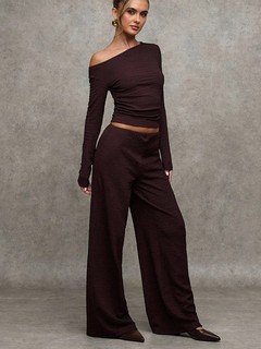 Three-quarter front view of the brown one-shoulder top and pants set, showing its silhouette and design details.