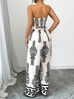 Back view of the white and black ornamental strapless jumpsuit, showing its silhouette and design details.