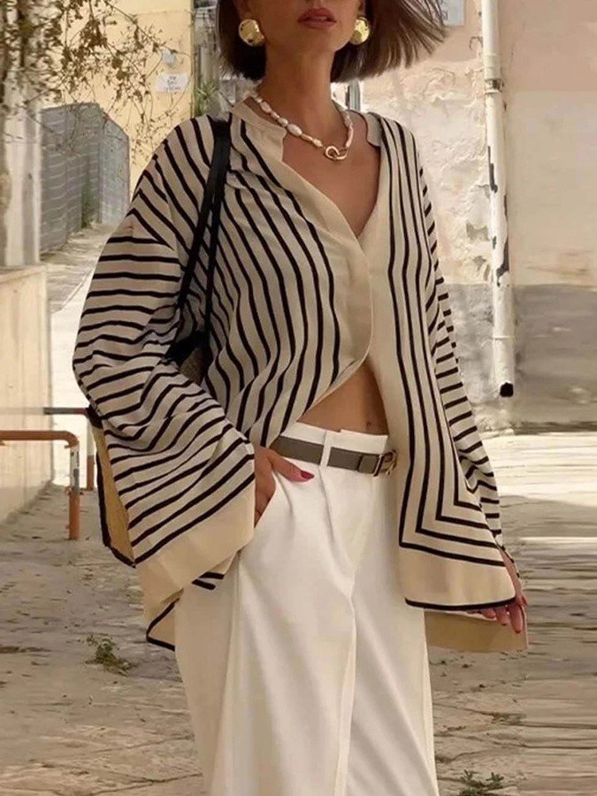 Angled front view of the cream and black striped border hem shirt, showing its silhouette and design details.
