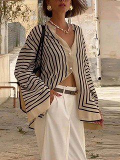 Three-quarter front view of the cream and black striped border hem shirt, showing its silhouette and design details.