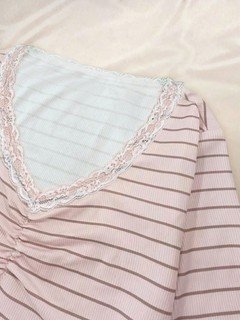 Neckline detail of the pink pink striped lace-trim v-neck long-sleeve top, showing fine stripes, lace-trim v-neck and long sleeves.