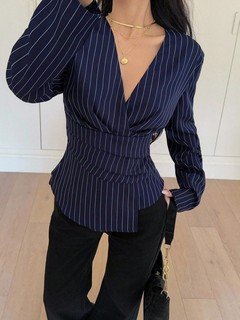 Angled front view of the navy pinstripe ruched-waist blouse, showing its silhouette and design details.