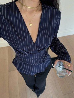 Close-up of the navy pinstripe ruched-waist blouse, showing its silhouette and design details.