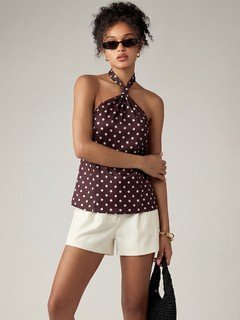 Front view of the brown polka-dot cross-halter top, showing its silhouette and design details.