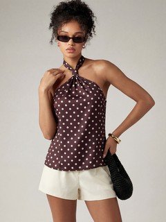 Full-length front view of the brown polka-dot cross-halter top, showing its silhouette and design details.