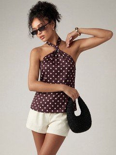 Styled front view of the brown polka-dot cross-halter top, showing its silhouette and design details.