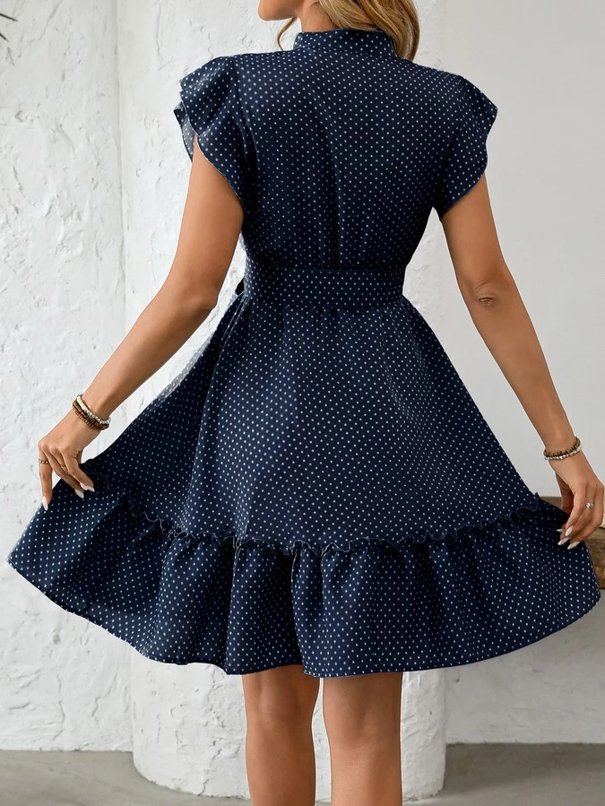 Back view of the navy polka-dot ruffle hem shirt dress, showing its silhouette and design details.