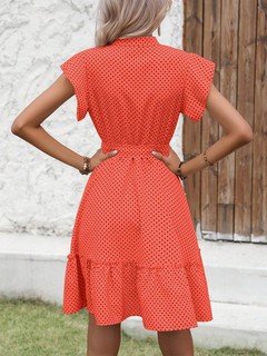 Back view of the coral polka-dot ruffle hem shirt dress, showing its silhouette and design details.