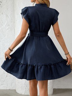 Back view of the navy polka-dot ruffle hem shirt dress, showing its silhouette and design details.
