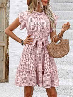 Angled front view of the pink polka-dot ruffle hem shirt dress, showing its silhouette and design details.