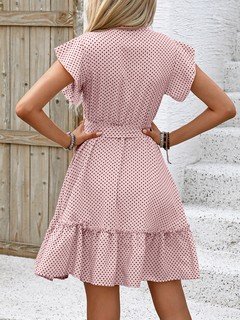 Back view of the pink polka-dot ruffle hem shirt dress, showing its silhouette and design details.