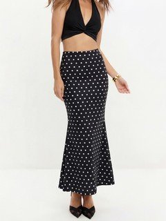 Lifestyle front view of the black polka-dot fishtail maxi skirt, showing its silhouette and design details.