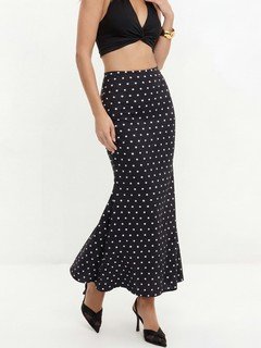 Styled front view of the black polka-dot fishtail maxi skirt, showing its silhouette and design details.