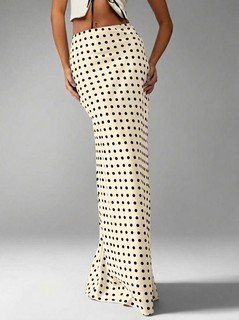 Angled front view of the cream polka-dot fishtail maxi skirt, showing its silhouette and design details.