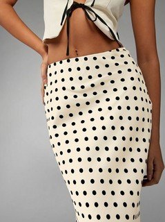 Close-up of the cream polka-dot fishtail maxi skirt, showing its silhouette and design details.