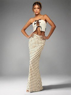 Full-length front view of the cream polka-dot fishtail maxi skirt, showing its silhouette and design details.