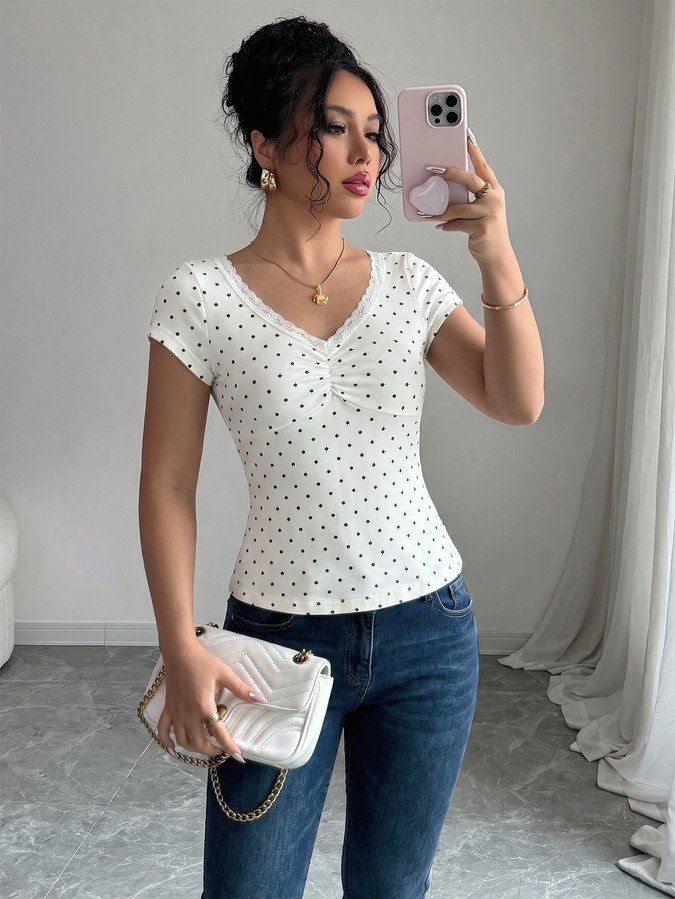 Front view of the white polka-dot lace-trim v-neck short-sleeve top, showing the silhouette and fit.
