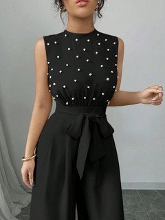 Bodice detail of the black polka-dot sleeveless tie-waist wide-leg jumpsuit, showing polka-dot bodice, tie waist and wide-leg pants.