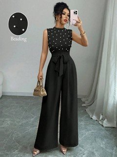 Front view of the black polka-dot sleeveless tie-waist wide-leg jumpsuit, showing the silhouette and fit.