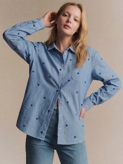 Angled front view of the blue polka-dot twist-front shirt, showing its silhouette and design details.