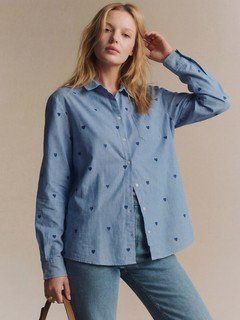 Lifestyle front view of the blue polka-dot twist-front shirt, showing its silhouette and design details.