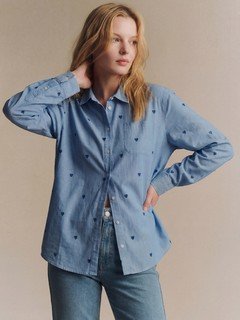 Styled front view of the blue polka-dot twist-front shirt, showing its silhouette and design details.