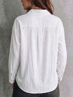 Back view of the white relaxed button-up long-sleeve shirt, showing the silhouette and fit.