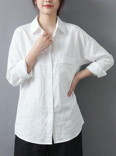 Full length front view of the white relaxed button-up long-sleeve shirt, showing the silhouette and fit.