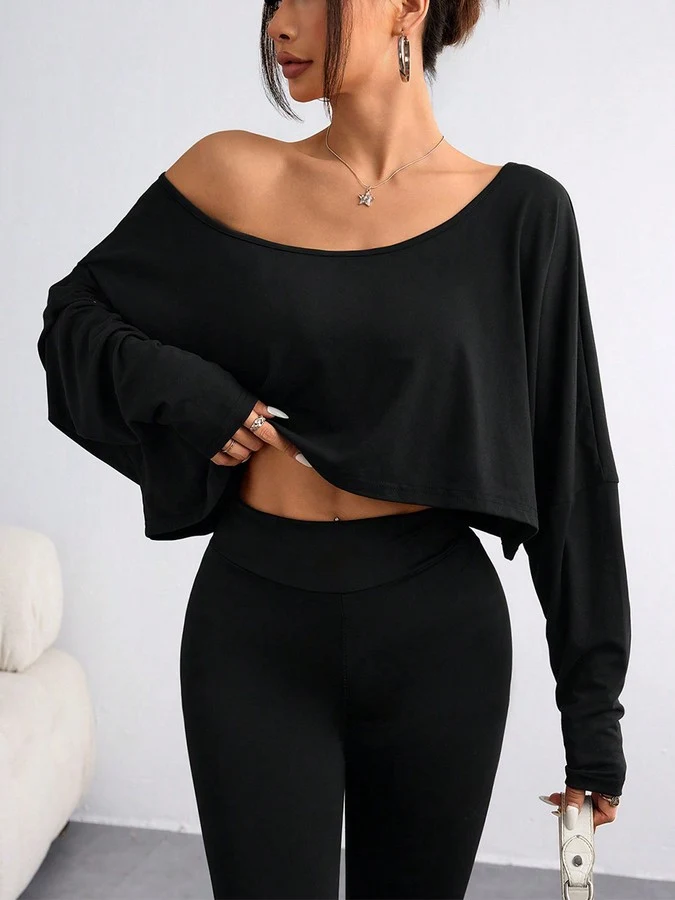 Front view of the black off-shoulder high-low crop top, showing its silhouette and design details.
