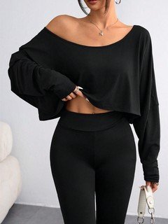 Lifestyle front view of the black off-shoulder high-low crop top, showing its silhouette and design details.