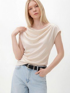 Lifestyle front view of the champagne satin cowl-neck cap-sleeve blouse, showing its silhouette and design details.
