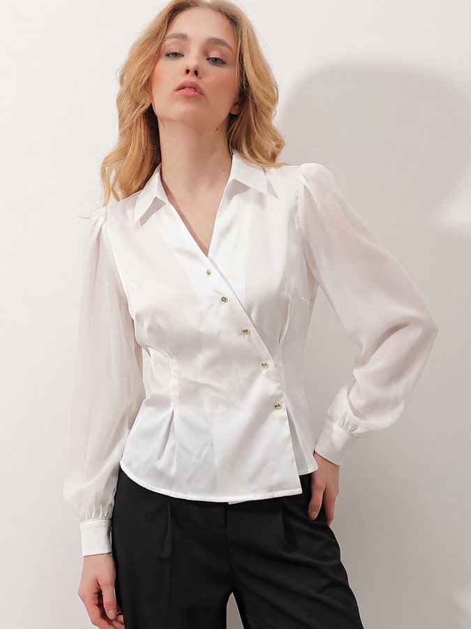 Front view of the ivory satin button-detail wrap blouse, showing its silhouette and design details.