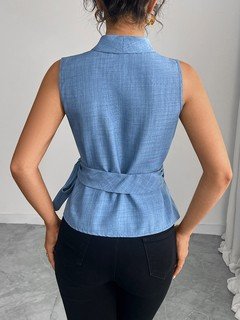 Angled back view of the blue sleeveless side-tie wrap top, showing its silhouette and design details.