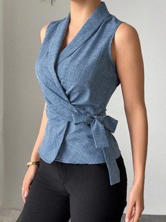 Angled front view of the blue sleeveless side-tie wrap top, showing its silhouette and design details.