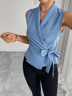 Front fit view of the blue sleeveless side-tie wrap top, showing its silhouette and design details.