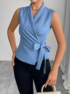 Lifestyle front view of the blue sleeveless side-tie wrap top, showing its silhouette and design details.