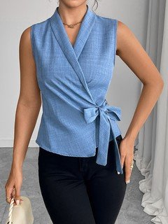 Three-quarter front view of the blue sleeveless side-tie wrap top, showing its silhouette and design details.