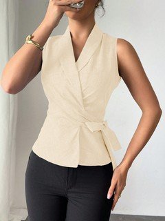 Full-length front view of the cream sleeveless side-tie wrap top, showing its silhouette and design details.