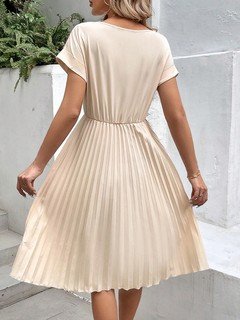 Back view of the cream short-sleeve pleated midi dress, showing its silhouette and design details.