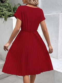 Back view of the red short-sleeve pleated midi dress, showing its silhouette and design details.