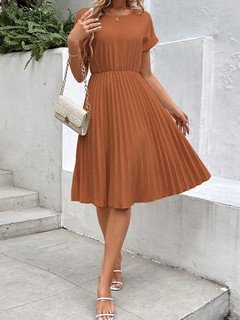 Styled front view of the rust short-sleeve pleated midi dress, showing its silhouette and design details.