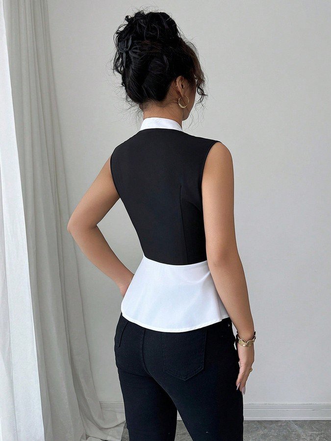 Back view of the black and white contrast-trim v-neck peplum top, showing its silhouette and design details.