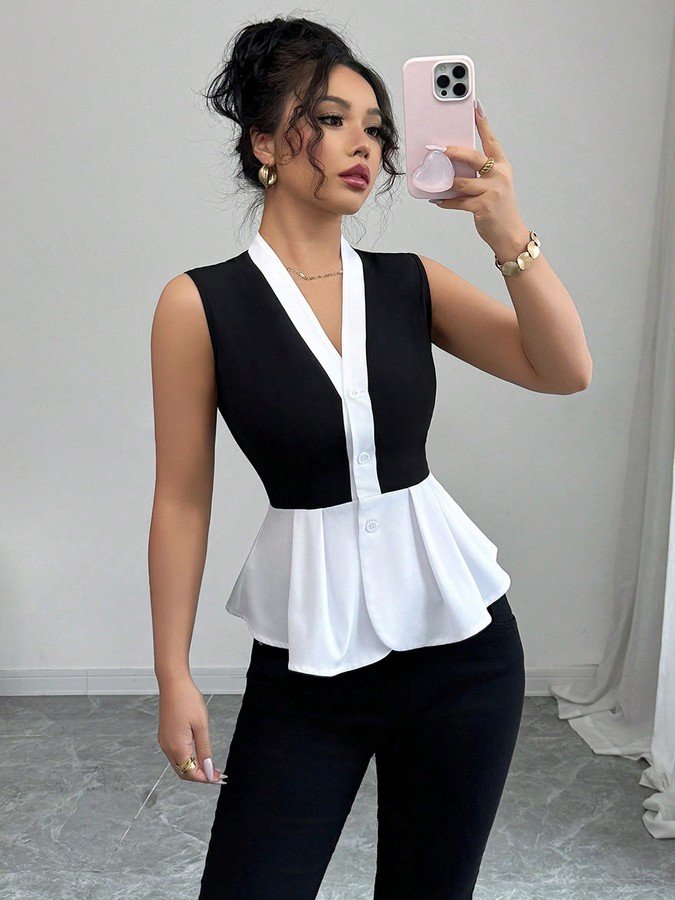 Front view of the black and white contrast-trim v-neck peplum top, showing its silhouette and design details.