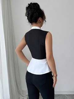 Back view of the black and white contrast-trim v-neck peplum top, showing its silhouette and design details.